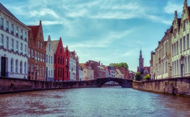 Ortaçağ evleriyle manzaralı şehir, Brugge 'de turistlerle dolu tekne ve kanal