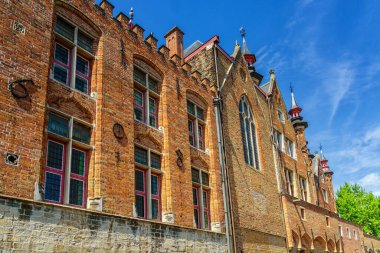 Kanal kıyısında eski binalar, tekneler ve Bruges güneşli mavi gökyüzü. Birçok kanalı ve eski binaları ile bu zarif şehir Unesco'nun dünya mirası dır. Kuzeybatı Belçika.