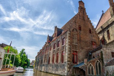 İlkbahar sabahı Bruges, Belçika 'da, kırmızı pencere çerçeveleri ve kanal manzaralı ortaçağ evleriyle manzaralı şehir manzarası