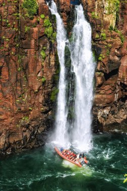 A boat with tourists under one of the many Iguazu waterfalls. clipart
