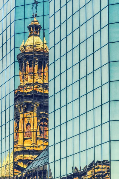 Reflection of the Cathedral of Santiago tower in the windows of the modern building at Plaza de Armas in Santiago, Chile