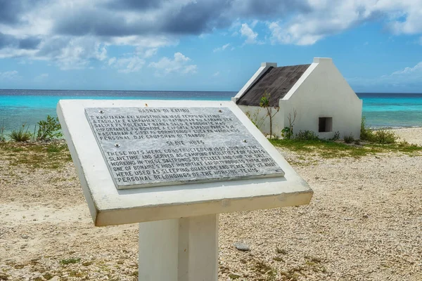 A sign located at the historic slave huts on the island tells the history of these buildings.