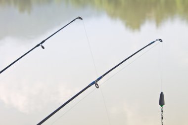 Fishing rods on riverside clipart