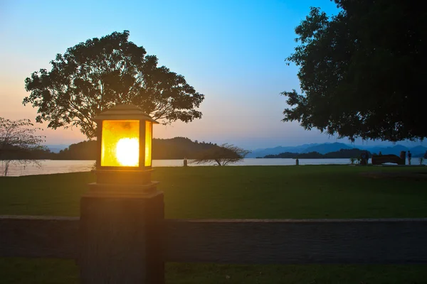 Belysning stolpe och solnedgången vid campingplatsen — Stockfoto