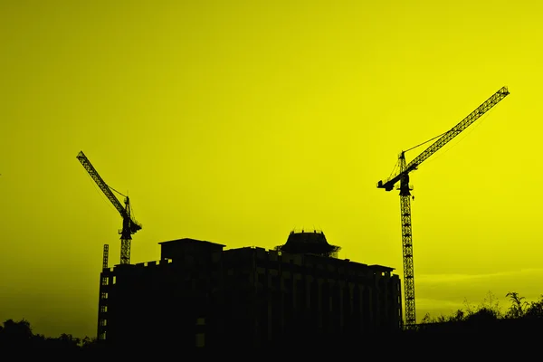 Gruas de construção e silhuetas de construção — Fotografia de Stock