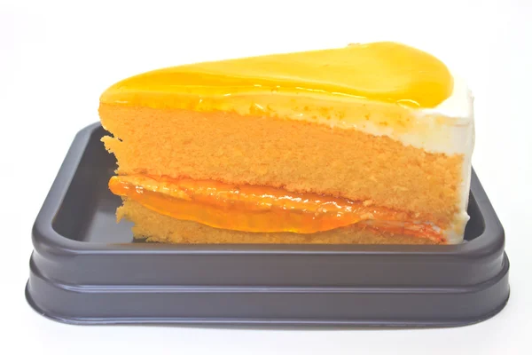 Oranje cheesecake in plaat op achtergrond — Stockfoto