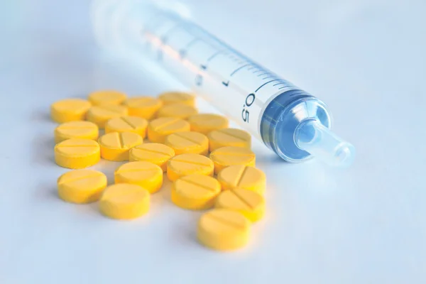 Ilaç tabletleri ve insülin şırınga gri tonda bulanık — Stok fotoğraf