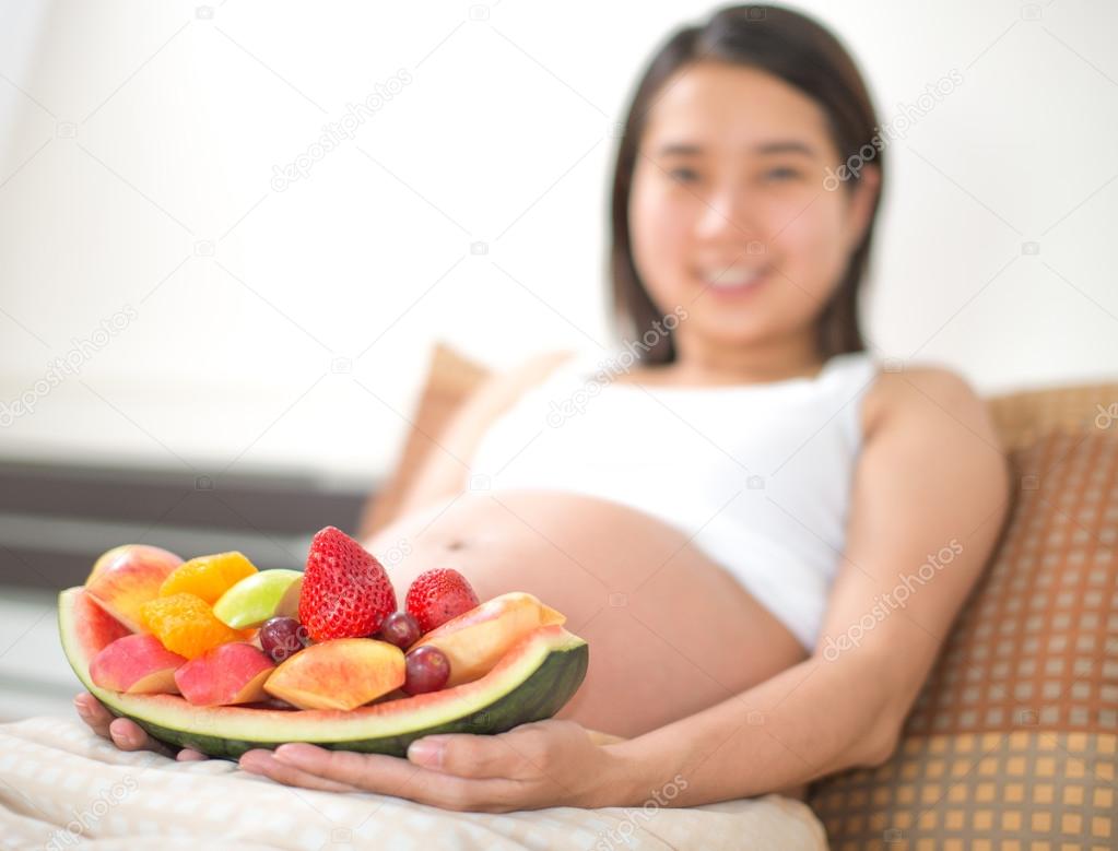 Portrait of asian pregnant women with fresh tasty sweet fruits d
