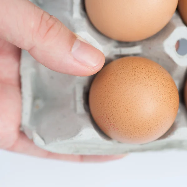 Huevos en bandeja con las manos — Foto de Stock