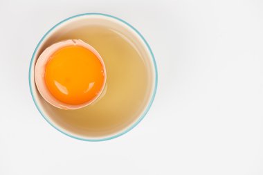 Separation the yolk of egg in little bowl clipart