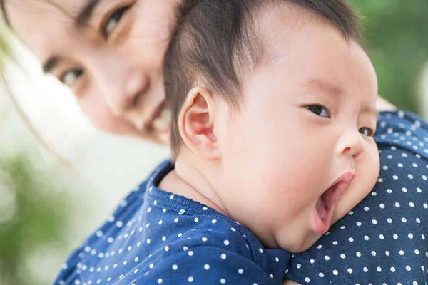 Feliz asiático madre abrazo adorable lindo bebé bostezo — Foto de Stock