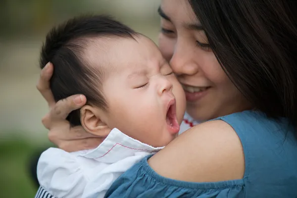 Felice mamma asiatica baciare il bambino carino sbadigliare — Foto Stock