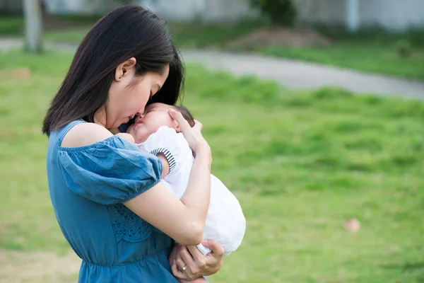 Asian mother kissing the cute baby — Stock Photo, Image