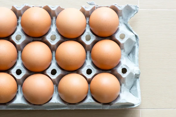 Huevos en la bandeja con fondo de madera claro — Foto de Stock