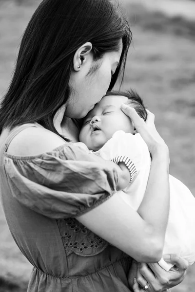 Siyah-beyaz Asya anne şirin bebek öpüşme Telifsiz Stok Imajlar