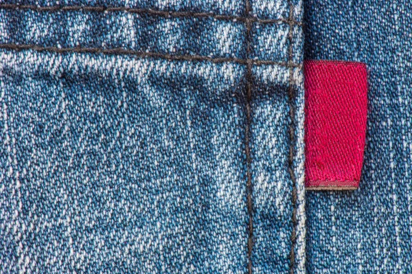 Blue Denim Jean con fondo de textura de etiqueta roja — Foto de Stock