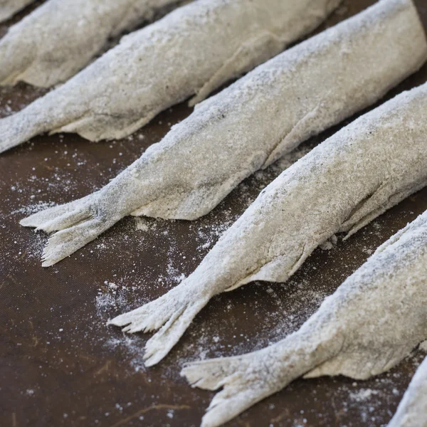 Małe ryby (gromadnika) posypane mąką przed pieczeniem — Zdjęcie stockowe