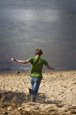 Arasında kum denize koşan genç adam