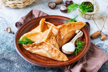 Pancakes kataef stuffed with fried mushrooms and onions in the form of triangles