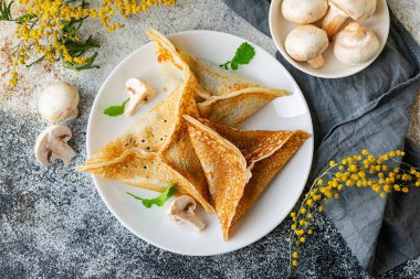Pancakes kataef stuffed with fried mushrooms and onions in the form of triangles