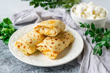 Pancakes stuffed with cottage cheese, parsley and dill in the form of rolls