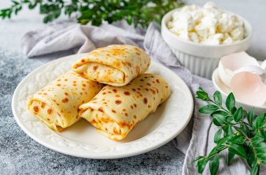 Pancakes stuffed with cottage cheese, parsley and dill in the form of rolls