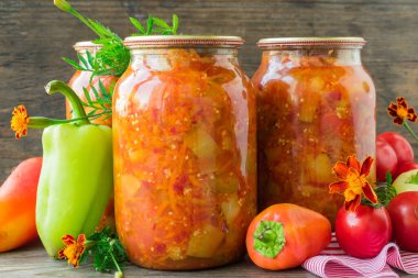 Cam kavanozlarda konserve patlıcan ve domates soslu dolma biber.