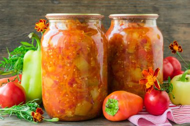 Cam kavanozlarda konserve patlıcan ve domates soslu dolma biber.
