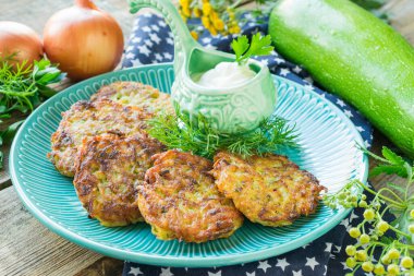 Tahta arka planda tavada kızarmış patates gözlemesi ve kabak.