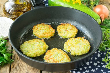 Tahta arka planda tavada kızarmış patates gözlemesi ve kabak.