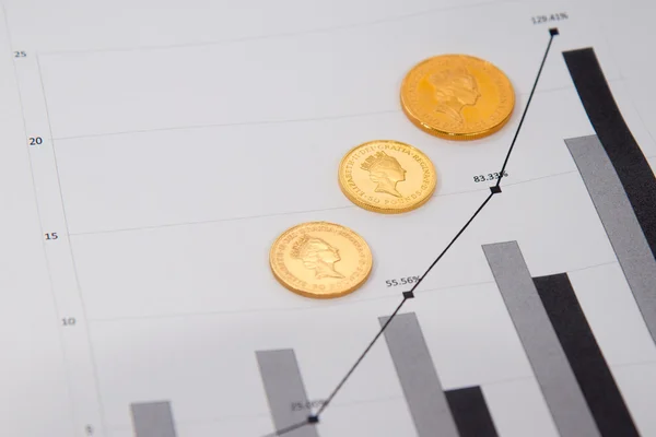 Moedas de ouro no gráfico financeiro — Fotografia de Stock
