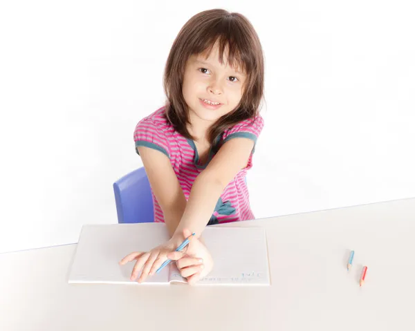 Child writing at desk — Stock Photo, Image