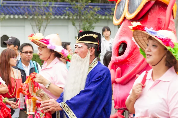 Gekostumeerde feestgangers maart met drijvers in de jaarlijkse droom parade o — Stockfoto