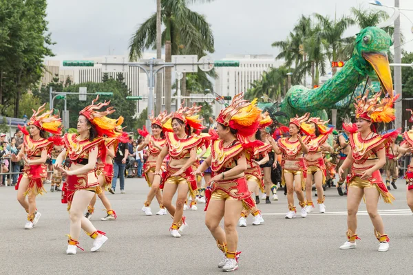 Gekostumeerde feestgangers maart met drijvers in de jaarlijkse droom parade o — Stockfoto