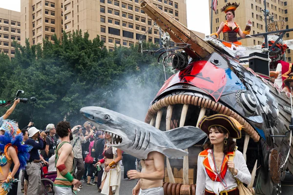 Gekostumeerde feestgangers maart met drijvers in de jaarlijkse droom parade o — Stockfoto