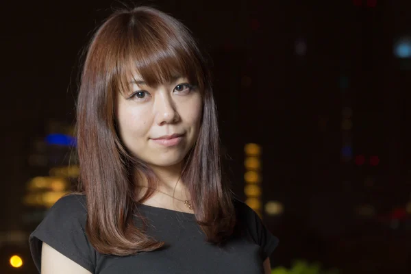 Ziemlich asiatische Frau mit Stadt Licht hinter ihr — Stockfoto