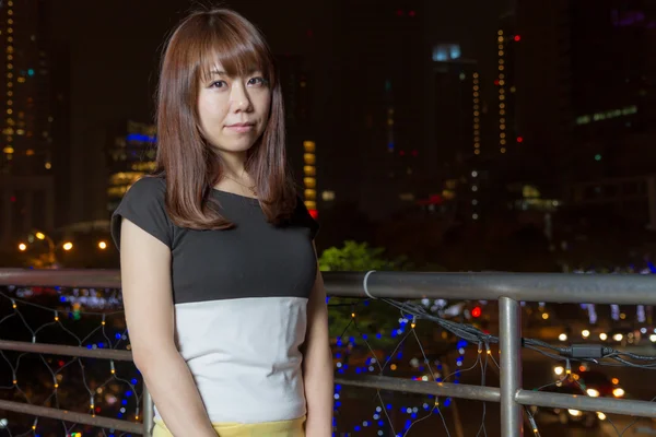 Mujer asiática bonita con luz de ciudad detrás de ella —  Fotos de Stock