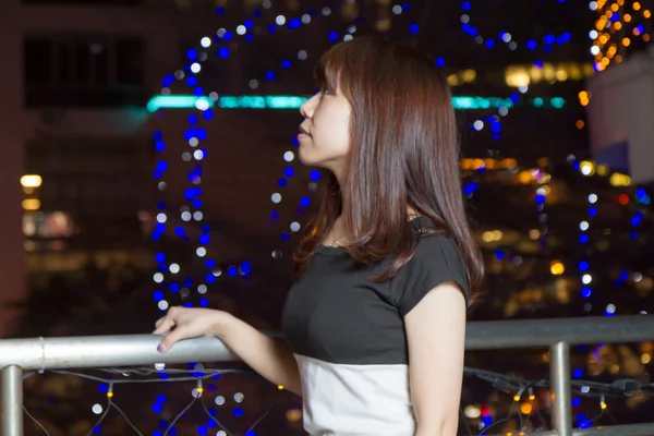 Mujer bastante asiática delante de las luces de la ciudad — Foto de Stock