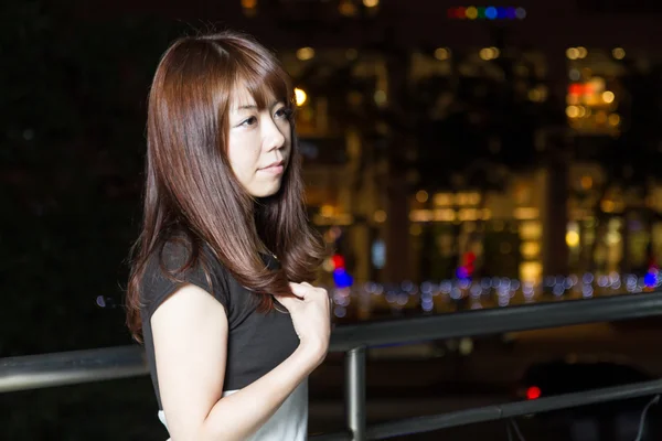 Attraktive asiatische Frau vor Einkaufszentrum mit hellen Lichtern — Stockfoto