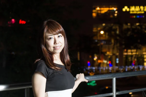 Attractive Asian Woman in front of Mall with bright LIghts