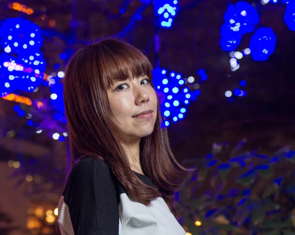 Hermosa mujer asiática con luces azules en el fondo — Foto de Stock