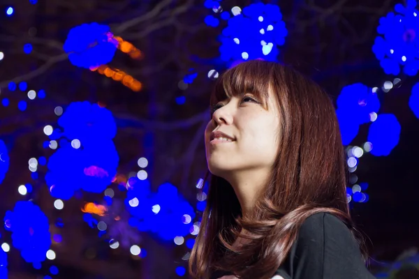 Beautiful Asian woman with blue lights in background — Stock Photo, Image