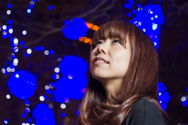 Krásná asijská žena s modrými světly v pozadí — Stock fotografie