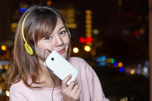 Bela jovem ásia mulher vestindo amarelo fones de ouvido — Fotografia de Stock