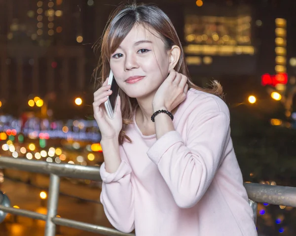 Красивая молодая азиатка с телефоном — стоковое фото