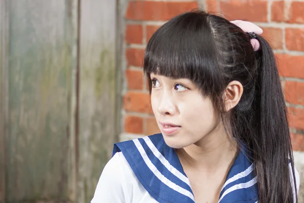 Asian schoolgirl in uniform outside school — Stock Photo, Image