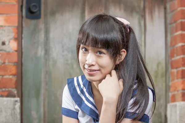 Asian schoolgirl in uniform outside school — Stock Photo, Image