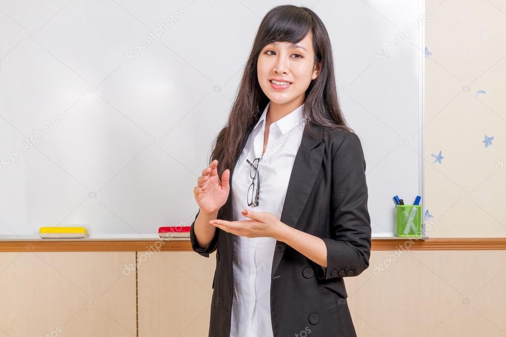 Chinese teacher in front of whiteboard explaining Stock Photo Chinese teacher in front of whiteboard explaining Stock Photo