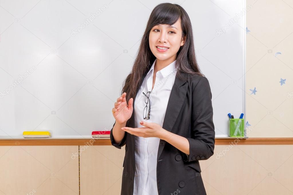 Chinese teacher in front of whiteboard explaining
