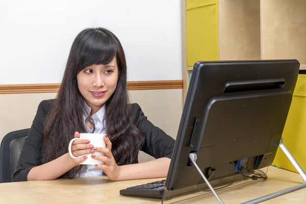 Portrait of Asian secretary sitting at desk — Stock Photo, Image